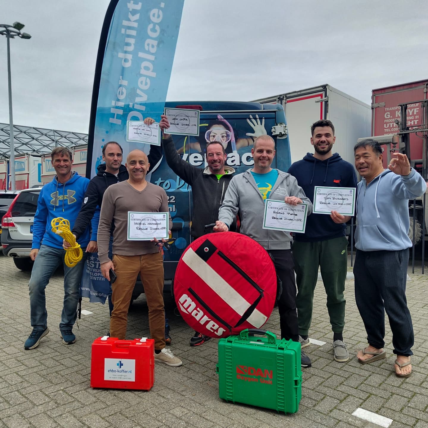 Het Diveplace team poseert trots met certificaten bij de Diveplace bus